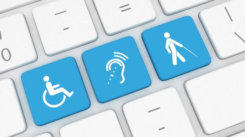 Ilustração mostra parte das teclas de um computador. Teclas brancas em sua maioria. Ao centro, vemos três teclas alinhadas em destaque na cor azul, contendo os símbolos de cadeirantes, surdos e pessoas cegas na cor branca.